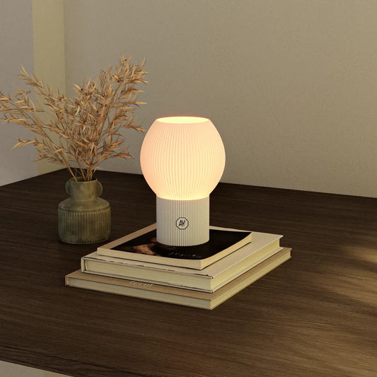 Lampe design AubeVolume LINEA S allumée — lumière chaude, base blanche, style épuré et écologique.
